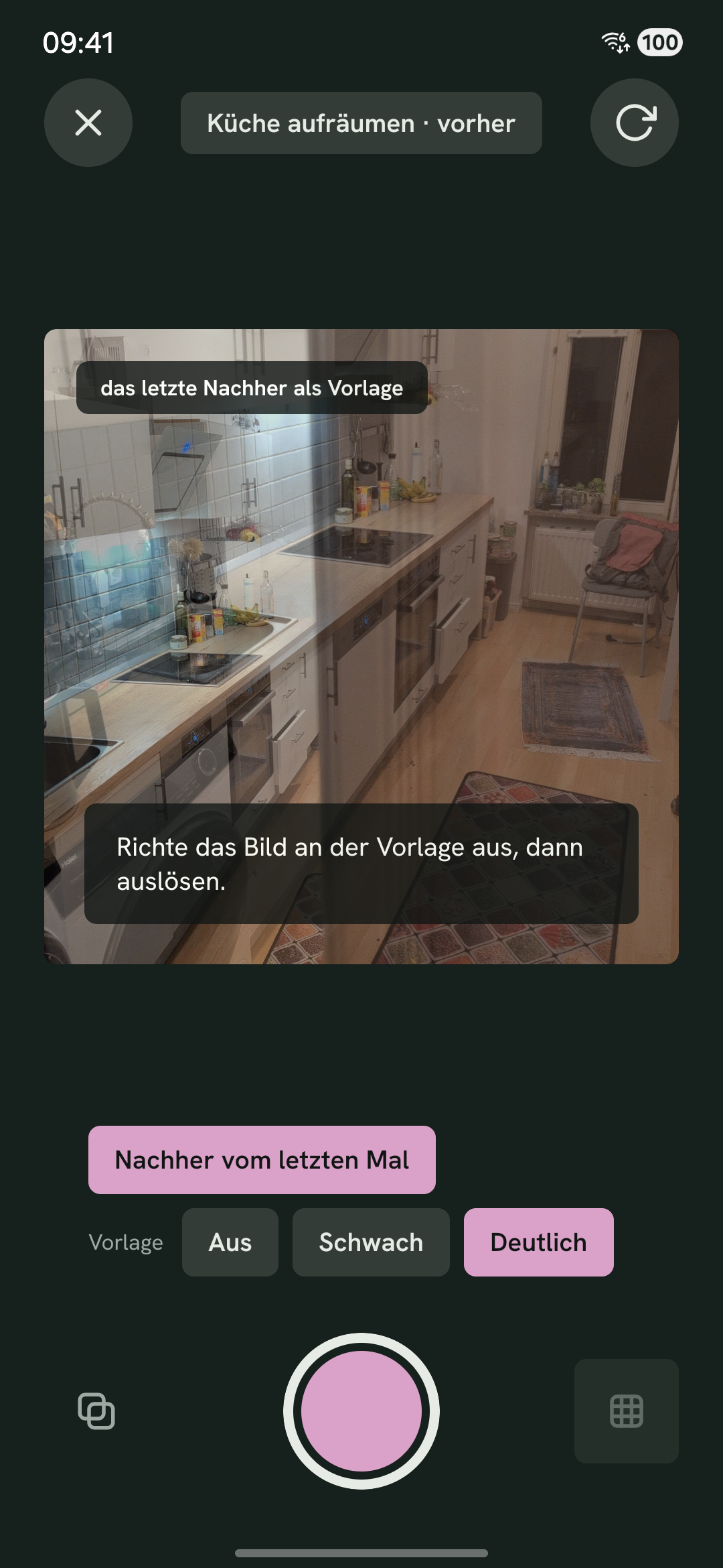 Die Kamera vor dem Vorher-Foto: das Nachher vom letzten Mal liegt halb durchsichtig über dem Sucher, der noch schief auf dieselbe Küche zeigt. Darunter die Wahl der Vorlage, auf Deutlich.